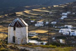 Un vecchio mulino a vento con la Chora sullo sfondo, isola di Kimolos (Grecia).



