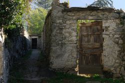 Un vecchio mura in pietra con porta in legno nella cittadina di Novate Mezzola, Lombardia.



