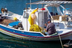 Un vecchio pescatore lavora alle sue reti nel porto di Lipsi, isola del Dodecaneso (Grecia) - © kokixx / Shutterstock.com