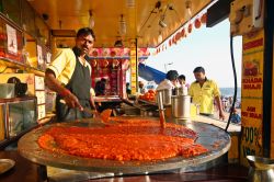 Un venditore di strada prepara cibo da fast food sulla spiaggia di Juhu a Mumbai, India - © silentwings / Shutterstock.com