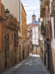 Un vicolo del centro storico di Alicante, Spagna. Sullo sfondo, la cupola blu della concattedrale dedicata a San Nicola di Bari.

