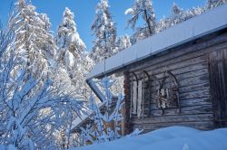 Una baita immersa nella neve a Lenzerheide con due slittini in legno, Svizzera. 



