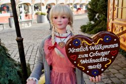 Una bambola in abiti tradizionali accoglie i visitatori al mercato natalizio di Coburgo, Germania.

