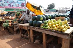 Una bancarella al mercato di Kampala, Uganda. Un uomo vende frutta all'angolo di una strada della capitale ugandese - © Nurlan Mammadzada / Shutterstock.com