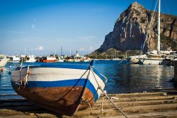 Una barca da pesca ormeggiata al porto di San Vito Lo Capo, Sicilia. Sullo sfondo, Monte Monaco, il massiccio roccioso che deve il suo nome alla forma che ricorda un monaco in ginocchio con ...