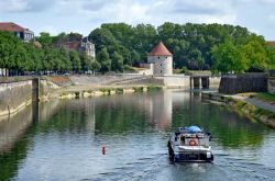 Una barca naviga sul fiume Doubs a Besancon, Francia. Sullo sfondo, la torre medievale Pelote - © Denis Costille / Shutterstock.com