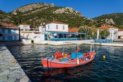 Una barchetta da pesca con il villaggio di Agia Kyriaki sullo sfondo, Trikeri (Grecia).
