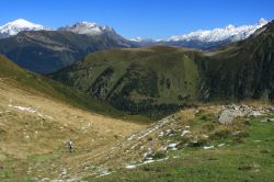 Una bella valle alpina vicino a Les Contamines-Montjoie, Francia: un escursionista ammira il paesaggio naturale.
