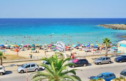 Una bella veduta della spiaggia di Marina di Pulsano con turisti nella stagione estiva, Taranto, Puglia - © phototravelua / Shutterstock.com