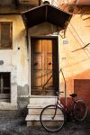 Una bicicletta davanti al portone d'ingresso di una casa a Popoli, Abruzzo. Una suggestiva immagine di vita quotidiana fotografata con la calda luce del tramonto - © TTL media / Shutterstock.com ...