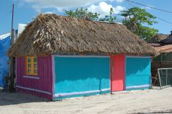 Una casa colorata con il tetto in paglia sull'isola di Holbox, Messico. In questo piccolo villaggio le strade sono di sabbia e non ci sono le macchine.
