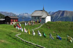 Una chiesa di Bettmeralp, Svizzera. Suggestivo il percorso allestito con le bandiere per raggiungere l'edificio religioso - © Peter Moulton / Shutterstock.com