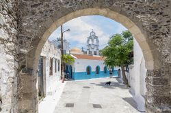 Una chiesetta del villaggio di Emporios, isola di Nisyros, vista da sotto un arco in pietra.
