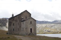 Una chiesetta di montagna in pietra vicino a un lago a Verres, Valle d'Aosta  - © fotosullenuvole / Shutterstock.com