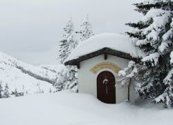 Una chiesetta innevata nello ski resort sulle Alpi austriache a Flachau. Sopra la porta si legge la scritta "Regina della Pace prega per noi" - © Alexander Chizhenok / Shutterstock.com ...