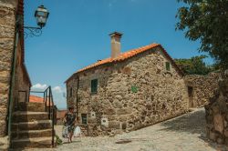 Una donna con le borse della spesa in un vicolo di Linhares da Beira, Portogallo - © Celli07 / Shutterstock.com