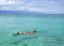 Una donna pratica snorkeling nelle acque di Cayos Cochinos, Honduras.
