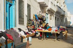 Una donna vende abbigliamento di seconda mano in una strada della Medina di Sfax, Tunisia - © Dmitry Chulov / Shutterstock.com