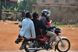 Una famiglia di cinque persone in sella a un motorino in una baraccopoli di Kampala, Uganda - © Oleg Znamenskiy / Shutterstock.com