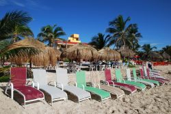 Una fila di lettini colorati nella spiaggia di un resort a Mahahual, Messico.

