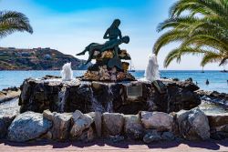 Una fontana con scultura di fronte alla spiaggia di Kini, isola di Syros, Grecia.



