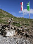 Una fontana di acqua potabile al rifugio Sillianer lungo il Carnic Peace Trail, Sillian (Austria). Sullo sfondo, la bandiera austriaca e quella del club alpino d'Austria.

