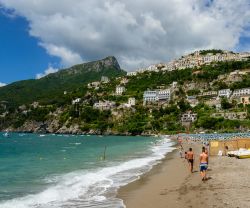 Una giornata assolata sulla spiaggia di Vietri sul Mare, Campania, Italia. Sulla collina verdeggiante s'inerpica la città di Vietri - © EugeniaSt / Shutterstock.com