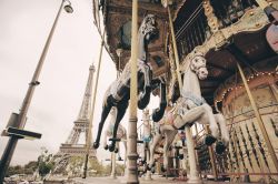 Una giostra a Parigi con la Torre Eiffel sullo sfondo