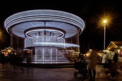 Una giostra per bambini illuminata di notte a Bayonne (Francia) in un mercatino natalizio.
