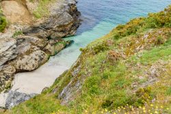 Una minuscola spiaggetta di sabbia bianca fra gli scogli sulla costa di Belle Ile en Mer, Francia.




