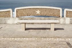 Una panchina lungo l'oceano a Ericeira, Portogallo. Dalla passeggiata che fiancheggia il litorale è possibile ammirare le acrobazie dei surfisti in azione.
