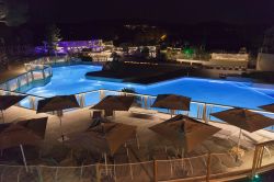 Una piscina deserta con ombrelloni fotografata di notte a Ramatuelle, Francia - © riekephotos / Shutterstock.com