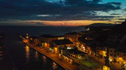 Una pittoresca veduta aerea di Castiglione della Pescaia by night (Toscana). Questo splendido borgo della Maremma ospita un centro storico con edifici religiosi e monumenti.
