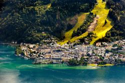 Una pittoresca veduta del lago di Zell e del villaggio di Zell-am-See, Austria. Sullo sfondo, le piste da sci in estate.

