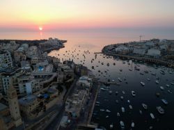 Una pittoresca veduta del porto di Marsascala fotografata all'alba con le barche ormeggiate (isola di Malta).
