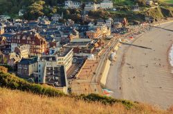 Una pittoresca veduta del villaggio marittimo di Etretat in Normandia, Francia. Questo piccolo gioiello dai tetti color blu è protetto da imponenti scogliere che richiamano turisti da ...