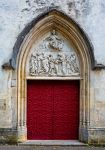 Una porta rossa con decorazioni scultoree nella chiesa di Sant'Orso a Montbard, Borgogna (Francia) - © Nigel Jarvis / Shutterstock.com