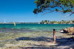 Una ragazza sulla spiaggia osserva il mare dei Caraibi, Giamaica. Questa terra offre lunghe spiagge, insenature protette, montagne scoscese, cascate, caverne e tante giornate di sole.

