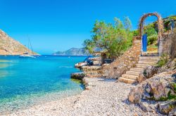 Una scala in pietra su una spiaggia di sabbia a Kalymnos, arcipelago del Dodecaneso (Grecia).

