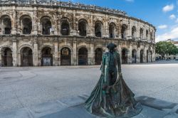 Una scultura di torero dinnanzi la Arena di Arles, antico Anfiteatro Romano della Provenza in Francia