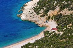 Una spiaggia di Lubenice sull'isola di Cres, Croazia. Il bianco della sabbia contrasta le sfumature blu del mare e il verde della vegetazione lussureggiante.

