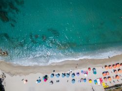 Una spiaggia di Ricadi, Vibo Valentia, con ombrelloni, sdraio e canoe. L'acqua del Tirreno che per 12 km lambisce le coste di questo territorio.


