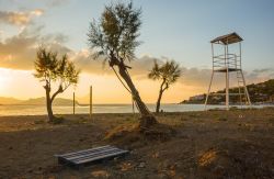 Una spiaggia di Scala, isola di Angistri, con campo da pallavolo e alberi al tramonto - © siete_vidas / Shutterstock.com