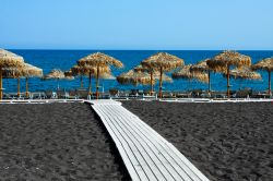 Una spiaggia nera a Santorini, isole Cicladi, Grecia. Ciottoli finissimi e sabbia nera caratterizzano questo tratto di litorale dell'isola di Santorini che vanta spiagge uniche e diverse ...