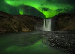 Una splendida aurora boreale sopra la cascata di Skogafoss, Skogar, Islanda.



