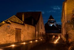 Una splendida veduta notturna del castello di Provins, Francia, con persone a passeggio.
