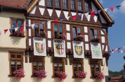 Una storica casa a graticcio con vecchie bandiere di Kempten, Memmingen, Isny e Lindau, Germania.
