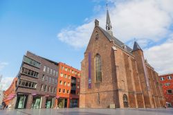 Una storica chiesa in mattoni nel centro di Nijmegen, Olanda. Su un lato, le vetrine dei negozi  - © akarapong / Shutterstock.com