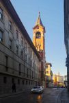 Una strada del centro storico di Asti e il campanile del Santuario di San Giuseppe