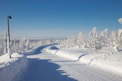 Una strada innevata nel villaggio di Saariselka, nord della Finlandia. Situata nel cuore della Lapponia finlandese, questa località è una destinazione turistica popolare.
